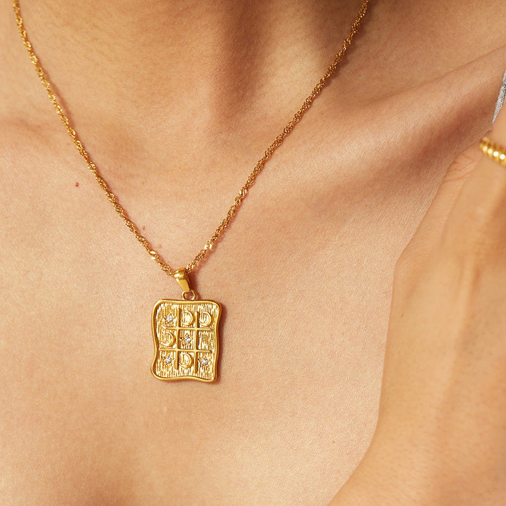 Elettra – Collana d’oro con piccoli ciondoli simbolici.